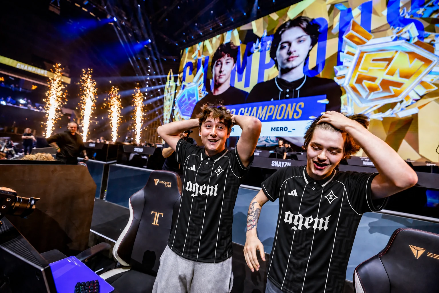 Two Agent players in black and ivory kits celebrating an FNCS championship victory on stage