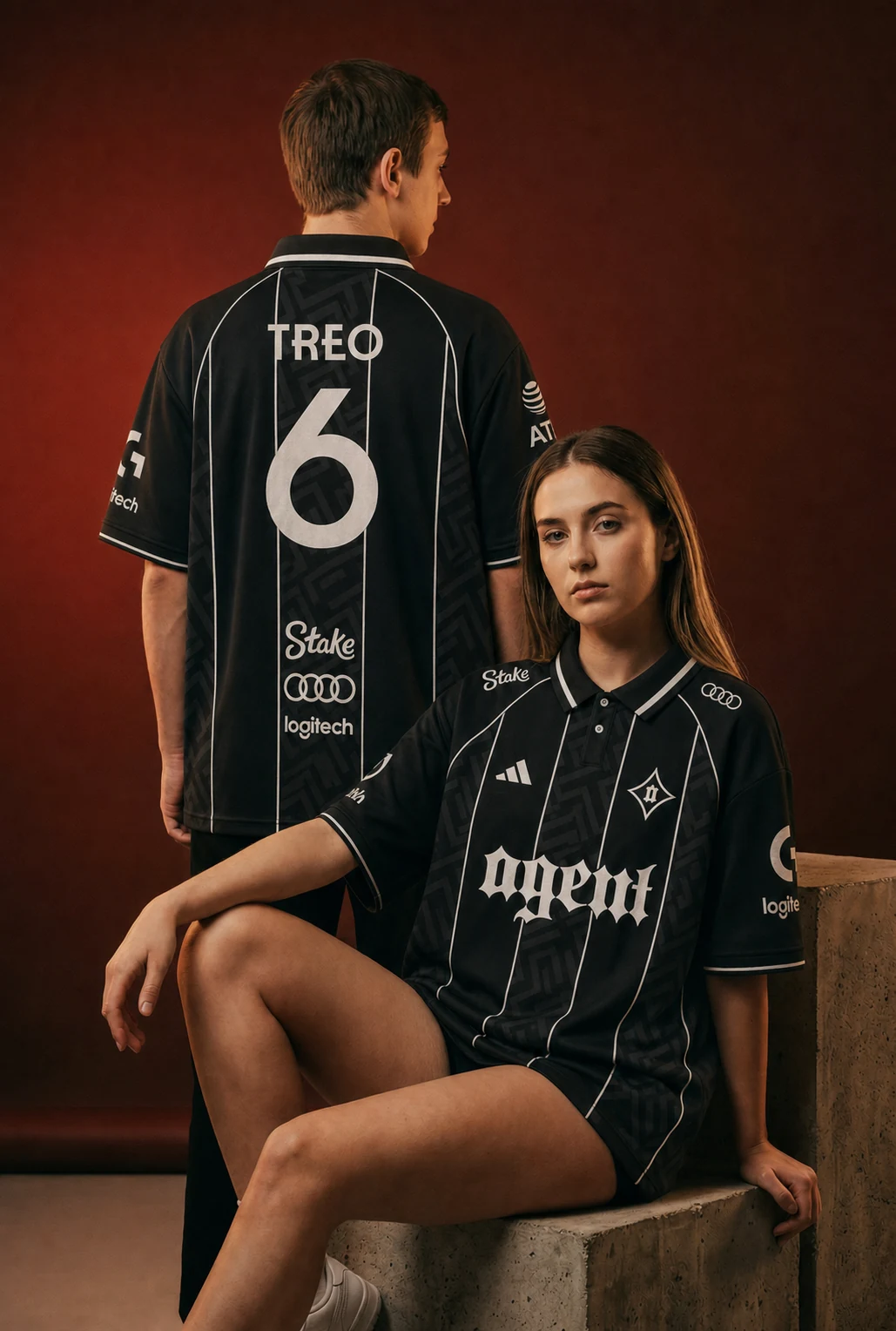 Two models wearing the Agent black kit with ivory trim in a warm red studio